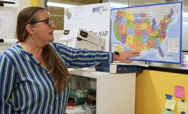 Dr. Angel Foster, co-founder of Massachusetts Medication Abortion Access Project, points out on a map of the United States where her organization provides care, May 13, 2025, in Somerville, Mass. (AP Photo/Charles Krupa)