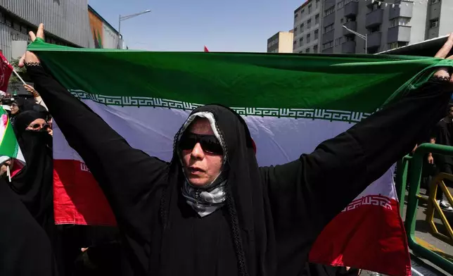 An Iranian worshipper carries her country's flag during a protest to condemn Israeli attacks on multiple cities across Iran, after the Friday prayers ceremony in Tehran, Iran, Friday, June 20, 2025. (AP Photo/Vahid Salemi)