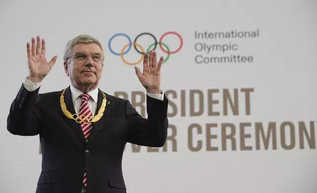 The outgoing IOC President Thomas Bach waves to the audience after receiving the Olympic order in gold prize during the handover ceremony of the IOC Presidency at Olympic House in Lausanne, Switzerland, Monday, June 23, 2025. (AP Photo/Laurent Cipriani)