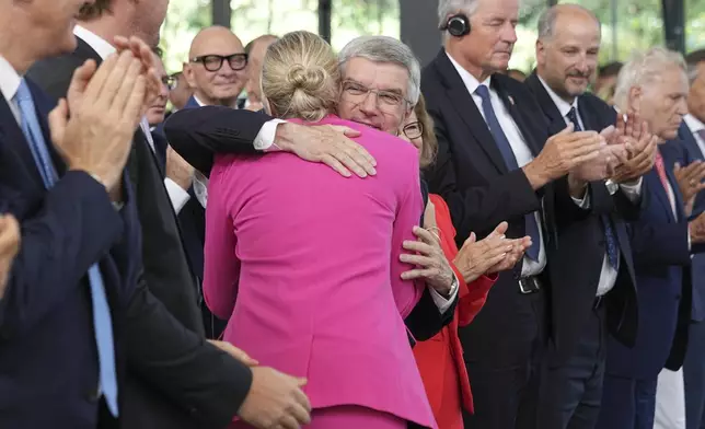 The outgoing IOC President Thomas Bach, right, hugs the new IOC President Kirsty Coventry during the handover ceremony of the IOC Presidency at Olympic House in Lausanne, Switzerland, Monday, June 23, 2025. (AP Photo/Laurent Cipriani)
