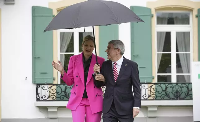 IOC President Thomas Bach, right, and President-elect Kirsty Coventry arrive for the handover ceremony of the IOC Presidency at Olympic House in Lausanne, Switzerland, Monday, June 23, 2025. (AP Photo/Laurent Cipriani)