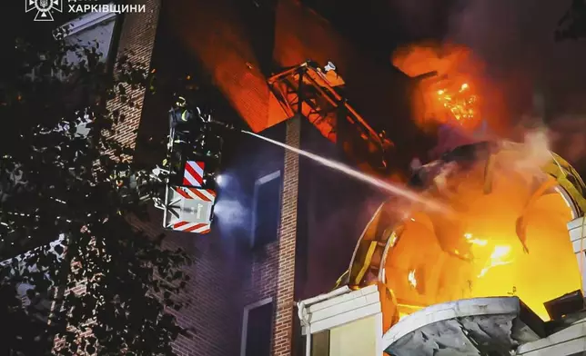 In this photo provided by the Ukrainian Emergency Service, firefighters put out a fire following Russia's massive air attack in Kharkiv, Ukraine, Friday, June 20, 2025. (Ukrainian Emergency Service via AP)