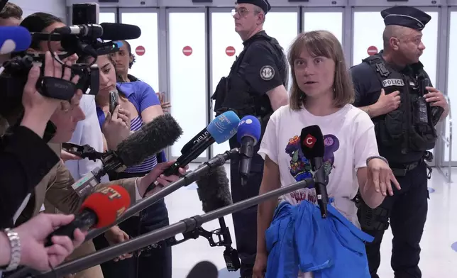 Activist Greta Thunberg answers reporters as she arrives from Israel at Charles de Gaulle airport, north of Paris, Tuesday, June 10, 2025. (AP Photo/Michel Euler)
