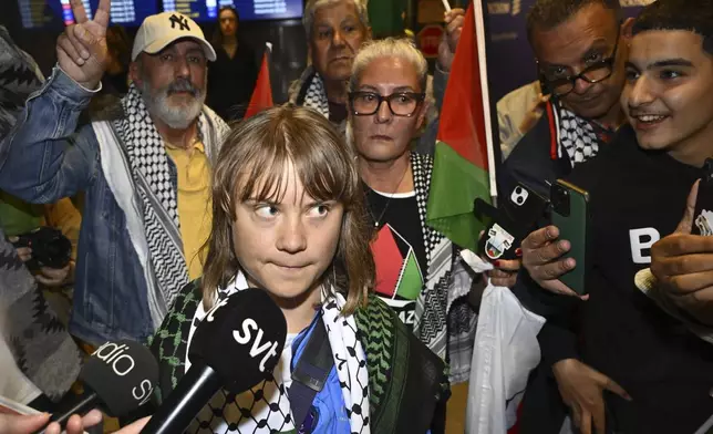 Swedish activist Greta Thunberg talks to journalists as she arrives at Stockholm Arlanda Airport outside Stockholm, Sweden, Tuesday June 10, 2025. (Anders Wiklund/TT News Agency via AP)