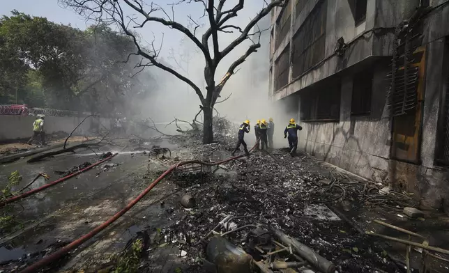 Firefighters work at the site of an airplane that crashed in India's northwestern city of Ahmedabad in Gujarat state, Thursday, June 12, 2025. (AP Photo/Ajit Solanki)