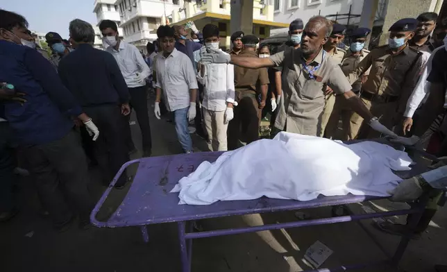 The remains of a victim is brought to Civil Hospital after an airplane crashed in India's northwestern city of Ahmedabad in Gujarat state, Thursday, June 12, 2025. (AP Photo/Ajit Solanki)
