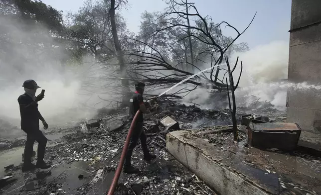 Firefighters work at the site of an airplane that crashed in India's northwestern city of Ahmedabad in Gujarat state, India, Thursday, June 12, 2025. (AP Photo/Ajit Solanki)