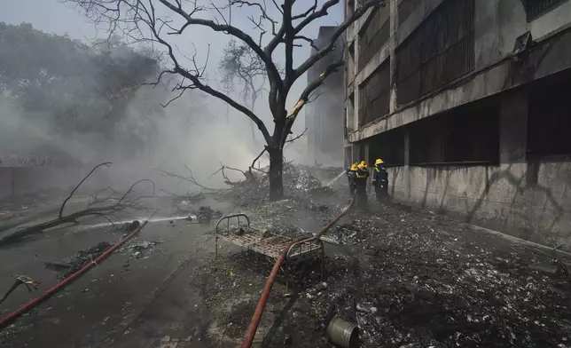 Firefighters work at the site of an airplane that crashed in India's northwestern city of Ahmedabad in Gujarat state, Thursday, June 12, 2025. (AP Photo/Ajit Solanki)