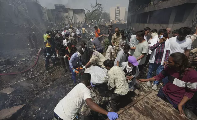 EDS NOTE GRAPHIC CONTENT- Rescuers carry the body of a victim of an airplane that crashed in India's northwestern city of Ahmedabad in Gujarat state, Thursday, June 12, 2025. (AP Photo/Ajit Solanki)