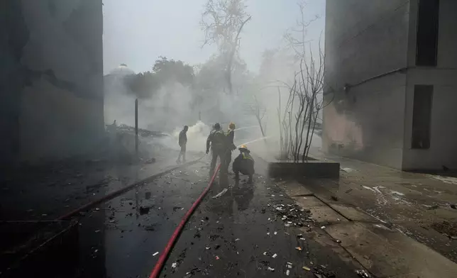 Firefighters work at the site of an airplane that crashed in India's northwestern city of Ahmedabad in Gujarat state, Thursday, June 12, 2025. (AP Photo/Ajit Solanki)