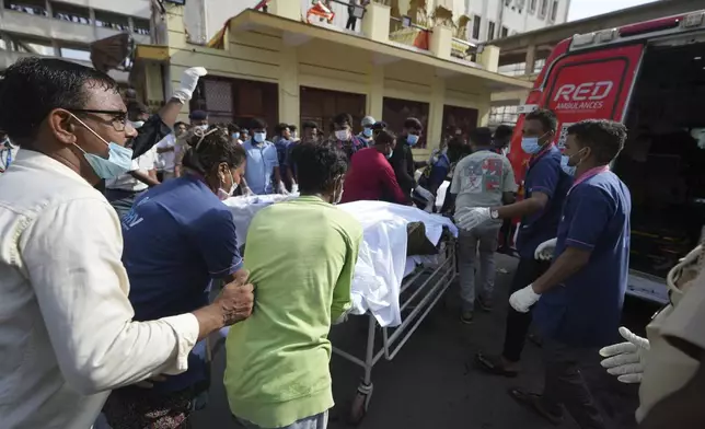 The body of a victim is brought to a hospital after an airplane crashed in India's northwestern city of Ahmedabad in Gujarat state, Thursday, June 12, 2025. (AP Photo/Ajit Solanki)