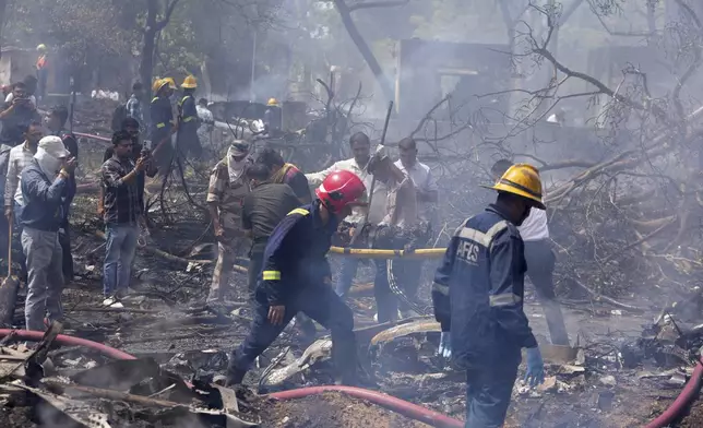 Firefighters work at the site of an airplane that crashed in India's northwestern city of Ahmedabad in Gujarat state, Thursday, June12, 2025. (AP Photo/Ajit Solanki)