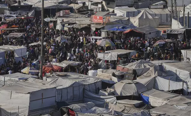 Displaced Palestinians walk trough a makeshift tent camp in Khan Younis, Gaza, on Wednesday, June 4, 2025. (AP Photo/Abdel Kareem Hana)