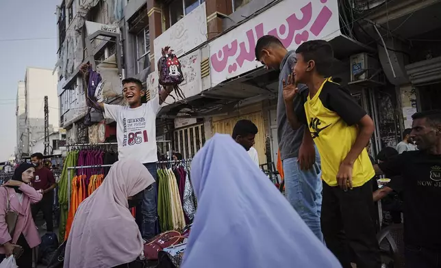 Palestinians walk trough a market ahead of the Muslim holiday of Eid al-Adha, in Gaza City on Thursday, June 5, 2025. (AP Photo/Jehad Alshrafi)