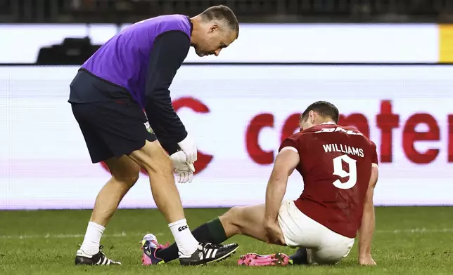 Tomos Williams of the British &amp; Irish Lions is attended to by a trainer as he grabs at his hamstring after scoring a try during their rugby match against the Western Force in Perth, Australia, Saturday, June 28, 2025. (AP Photo/Trevor Collens)
