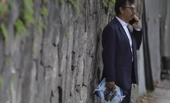 Jaime Quintanilla, attorney for Salvador Enrique Anaya, a critic of President Nayib Bukele's government, speaks on his cell phone outside a police station after arriving to visit his client in San Salvador, Tuesday, June 10, 2025. Anaya was detained on June 7 for alleged money laundering and asset laundering. (AP Photo/Salvador Melendez)