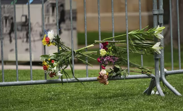 Flowers are placed along a makeshift barrier outside of the Boulder County, Colo., courthouse after Sunday's attack, Monday, June 2, 2025, in Boulder, Colo. (AP Photo/David Zalubowski)