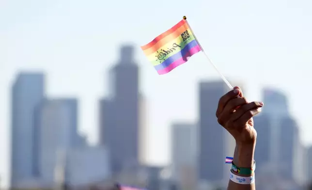 A pride flag is waved against the downtown Los Angeles skyline during the LA Pride in the Park festival at Los Angeles State Historic Park, June 8, 2024, in Los Angeles. (AP Photo/Chris Pizzello)