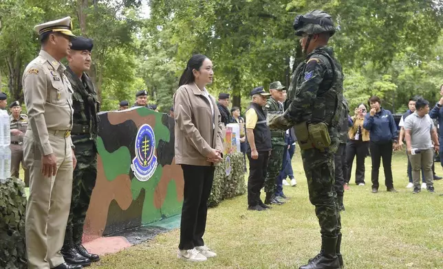 In this photo released by Thailand's Government Spokesman Office, Thailand's Prime Minister Paetongtarn Shinawatra, center, talks to a Thai soldier in Sa Kaeo Province, Thailand, Thursday, June 26, 2025.(Thailand's Government Spokesman Office via AP)