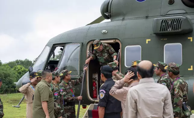 In this photo released by Agence Kampuchea Press (AKP), Cambodian Senate President Hun Sen, center, gets off from a helicopter during his visit to Oddar Meanchey province, near Cambodia-Thailand border of northern province of Cambodia, Thursday, June 26, 2025. (AKP via AP)