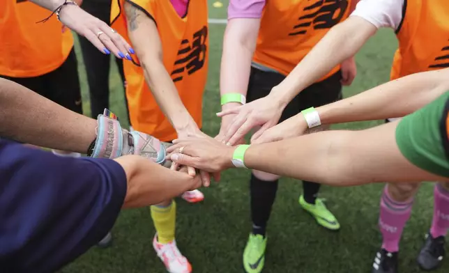 A team taps hands during an inclusive six a side soccer friendly tournament in London, Sunday, June 1, 2025. (AP Photo/Alastair Grant)