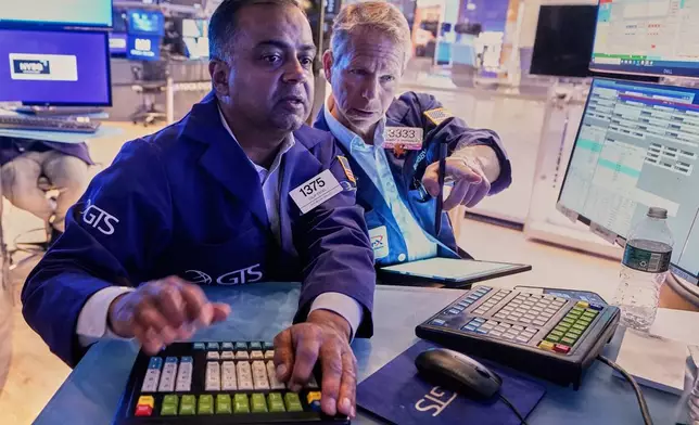Specialist Dilip Patel, left, and trader Robert Charmak work on the floor of the New York Stock Exchange, Monday, June 23, 2025. (AP Photo/Richard Drew)