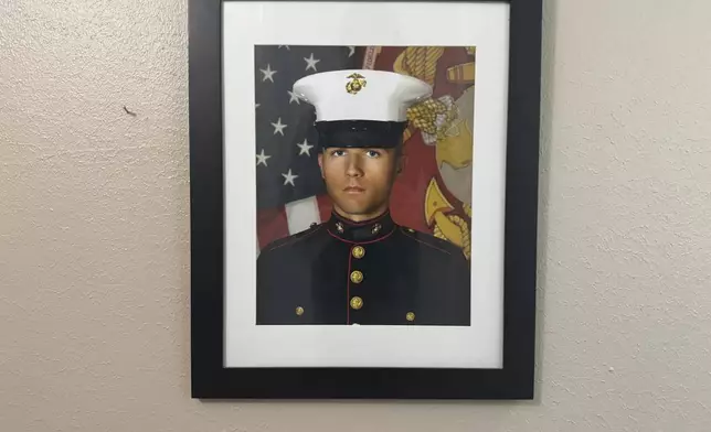 A portrait of Adrian Clouatre during his years of service with the U.S. Marine Corps hangs on the wall of his family's home in Baton Rouge on Tuesday, June 17, 2025. (AP Photo/Jack Brook)