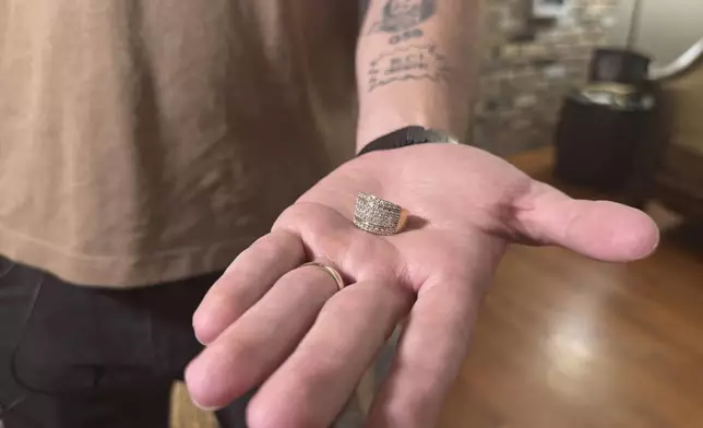 U.S. Marine Corps veteran Adrian Clouatre holds his wife Paola's wedding ring at his house in Baton Rouge, La. on Tuesday, June 17, 2025, which she gave to him after being arrested by ICE officers in May. (AP Photo/Jack Brook)