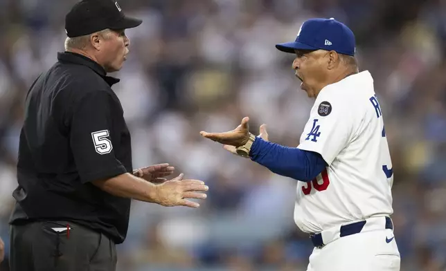 Los Angeles Dodgers manager Dave Roberts, right, argues with umpire Marvin Hudson after getting ejected during the third inning of a baseball game against the San Diego Padres in Los Angeles, Tuesday, June 17, 2025. (AP Photo/Kyusung Gong)