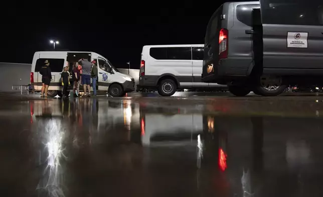 Members of Project ICECHIP gather in the Walmart parking lot to measure, weigh and crush hail during an operation late Friday, June 6, 2025, in Levelland, Texas. (AP Photo/Carolyn Kaster)