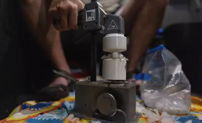 Jake Sorber crushes hail in the Walmart parking lot during a Project ICECHIP operation Friday, June 6, 2025, in Levelland, Texas. (AP Photo/Carolyn Kaster)