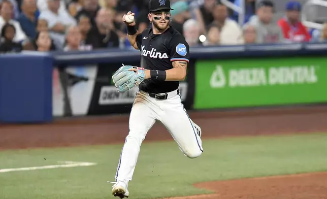 Miami Marlins third baseman Connor Norby holds the ball hit by Atlanta Braves' Ronald Acuña Jr. during the fifth inning of a baseball game Friday, June 20, 2025, in Miami. (AP Photo/Michael Laughlin)