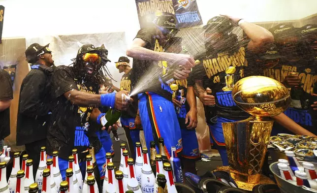 Oklahoma City Thunder guard Luguentz Dort, left, celebrates with teammates in the locker room after winning the NBA basketball championship with a Game 7 victory against the Indiana Pacers Sunday, June 22, 2025, in Oklahoma City. (AP Photo/Julio Cortez)