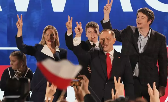 Presidential candidate Karol Nawrocki, a conservative historian backed by the right-wing Law and Justice party, second right, greets supporters at his headquarters after the presidential election runoff in Warsaw, Poland, Sunday, June 1, 2025. (AP Photo/Czarek Sokolowski)