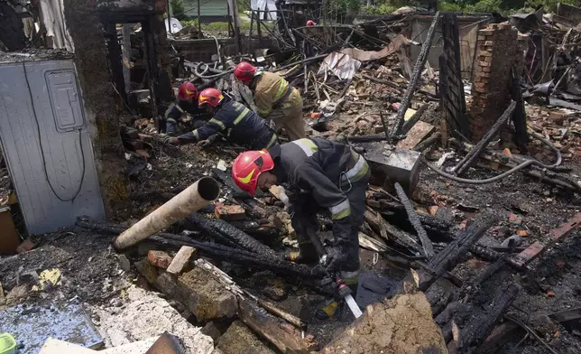 Rescue workers extinguish a fire of a house destroyed by a Russian drone strike in Pryluky village, Ukraine, Thursday, June 5, 2025. (AP Photo/Evgeniy Maloletka)