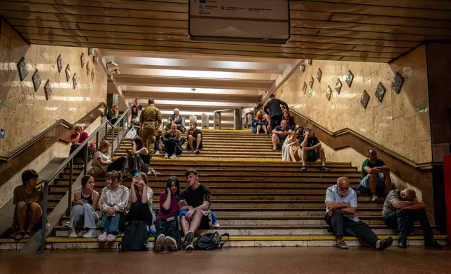 People rest in a metro station, being used as a bomb shelter, during a Russian drones attack in Kyiv, Ukraine, early Friday, June 6, 2025. (AP Photo/Dan Bashakov)