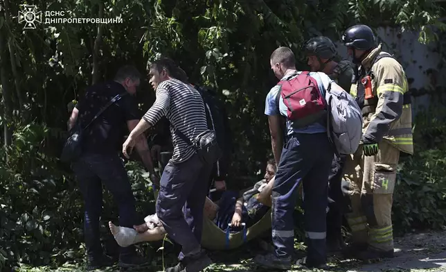 In this photo provided by the Ukrainian Emergency Service, rescuers carry an injured civilian following Russia's missile attack in Dnipro, Ukraine, Tuesday, June 24, 2025. (Ukrainian Emergency Service via AP)