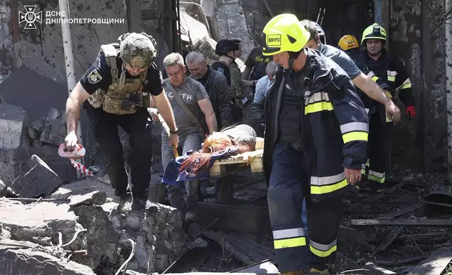 In this photo provided by the Ukrainian Emergency Service, rescuers carry an injured civilian following Russia's missile attack in Dnipro, Ukraine, Tuesday, June 24, 2025. (Ukrainian Emergency Service via AP)