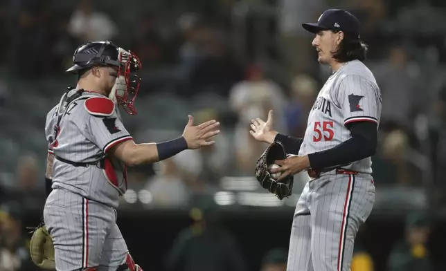 Minnesota Twins pitcher Kody Funderburk, right, celebrates with Christian Vázquez, left, after their victory over the Athletics in a baseball game Monday, June 2, 2025, in West Sacramento, Calif. (AP Photo/Scott Marshall)