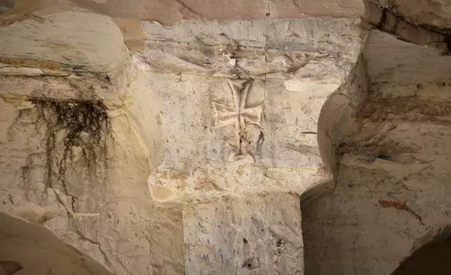 A sign of the cross is etched into the top of a stone column at a Byzantine underground tomb complex, believed to be over 1,500 years old, uncovered by a contractor during reconstruction of a war-damaged house in Maarat al-Numan, Idlib suburb, Syria, on Friday, May 30, 2025. (AP Photo/Omar Albam)