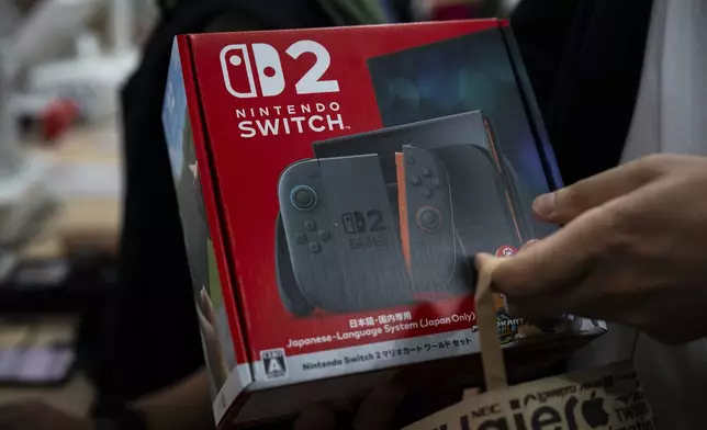 A customer purchases Nintendo Switch 2 at an electronics retailer in Tokyo, Thursday, June 5, 2025. (AP Photo/Louise Delmotte)