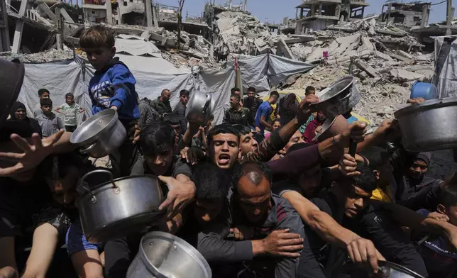 Palestinians struggle to get donated food at a community kitchen in Beit Lahia, northern Gaza Strip, May 3, 2025. (AP Photo/Jehad Alshrafi)
