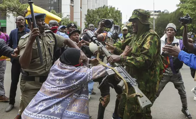 A protester scuffles with a police officer during a protest over the death in police custody of blogger Albert Ojwang, in Nairobi, Kenya, Thursday, June 12, 2025. (AP Photo/Andrew Kasuku)