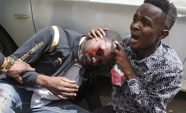 A demonstrator is attended to after being injured during a protest over the death in police custody of blogger Albert Ojwang, in Nairobi, Kenya, Thursday, June 12, 2025. (AP Photo/Andrew Kasuku)