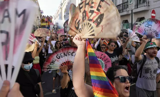 People hold up fans with pro-Palestinian messages and shout slogans during the Europride Parade in Lisbon, Saturday, June 21, 2025. (AP Photo/Armando Franca)