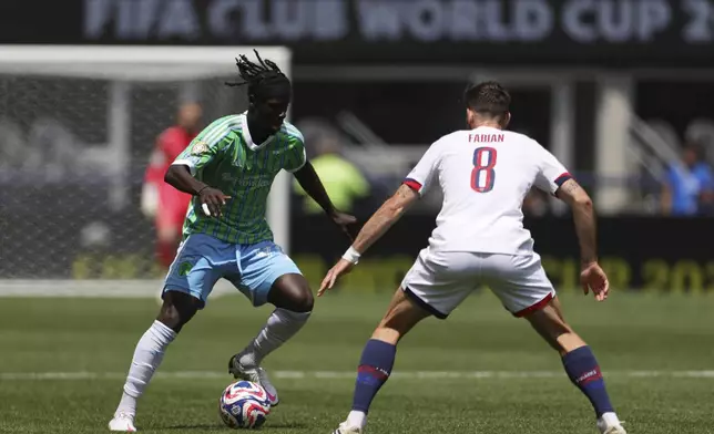 Seattle Sounders' Georgi Minoungou, left, controls the ball as Paris Saint-Germain's Fabian Ruiz defends during the Club World Cup Group B soccer match between Seattle Sounders and PSG in Seattle, Monday, June 23, 2025. (AP Photo/Ryan Sun)