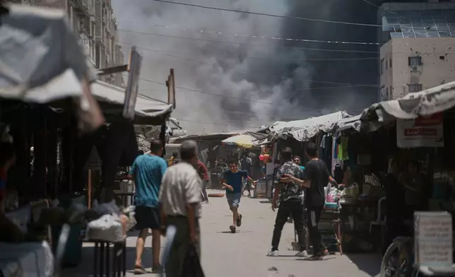 Palestinians look on as smoke rises to the sky following an Israeli strike in Gaza City, Sunday, June 1, 2025. (AP Photo/Jehad Alshrafi)