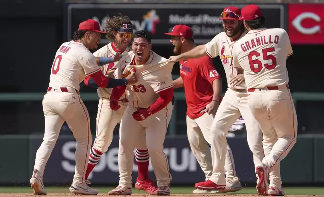 St. Louis Cardinals' Yohel Pozo (63) is congratulated by teammates after hitting a walk-off single in the 11th inning to defeat the Cincinnati Reds in a baseball game Saturday, June 21, 2025, in St. Louis. (AP Photo/Jeff Roberson)