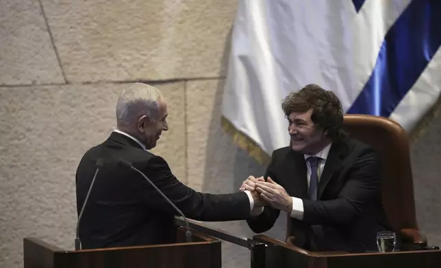 Israel's Prime Minister Benjamin Netanyahu, left, greets Argentina's President Javier Milei in the Knesset, Israel's parliament, in Jerusalem, Wednesday, June 11, 2025. (AP Photo/Ohad Zwigenberg)