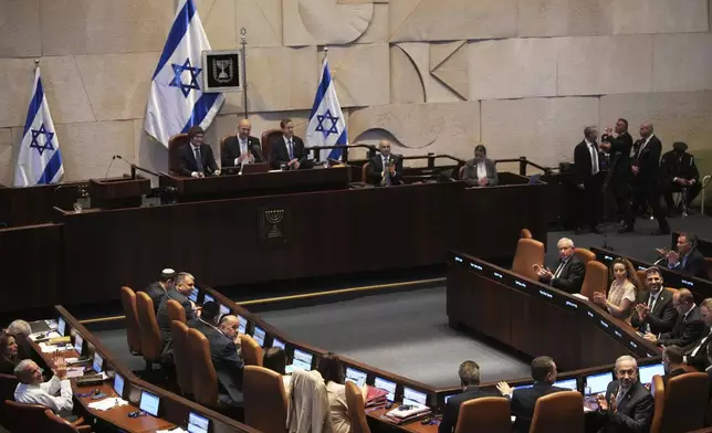 Argentina's President Javier Milei, seated back left, is welcomed by lawmakers in the Knesset, Israel's parliament, in Jerusalem, Wednesday, June 11, 2025. (AP Photo/Ohad Zwigenberg)